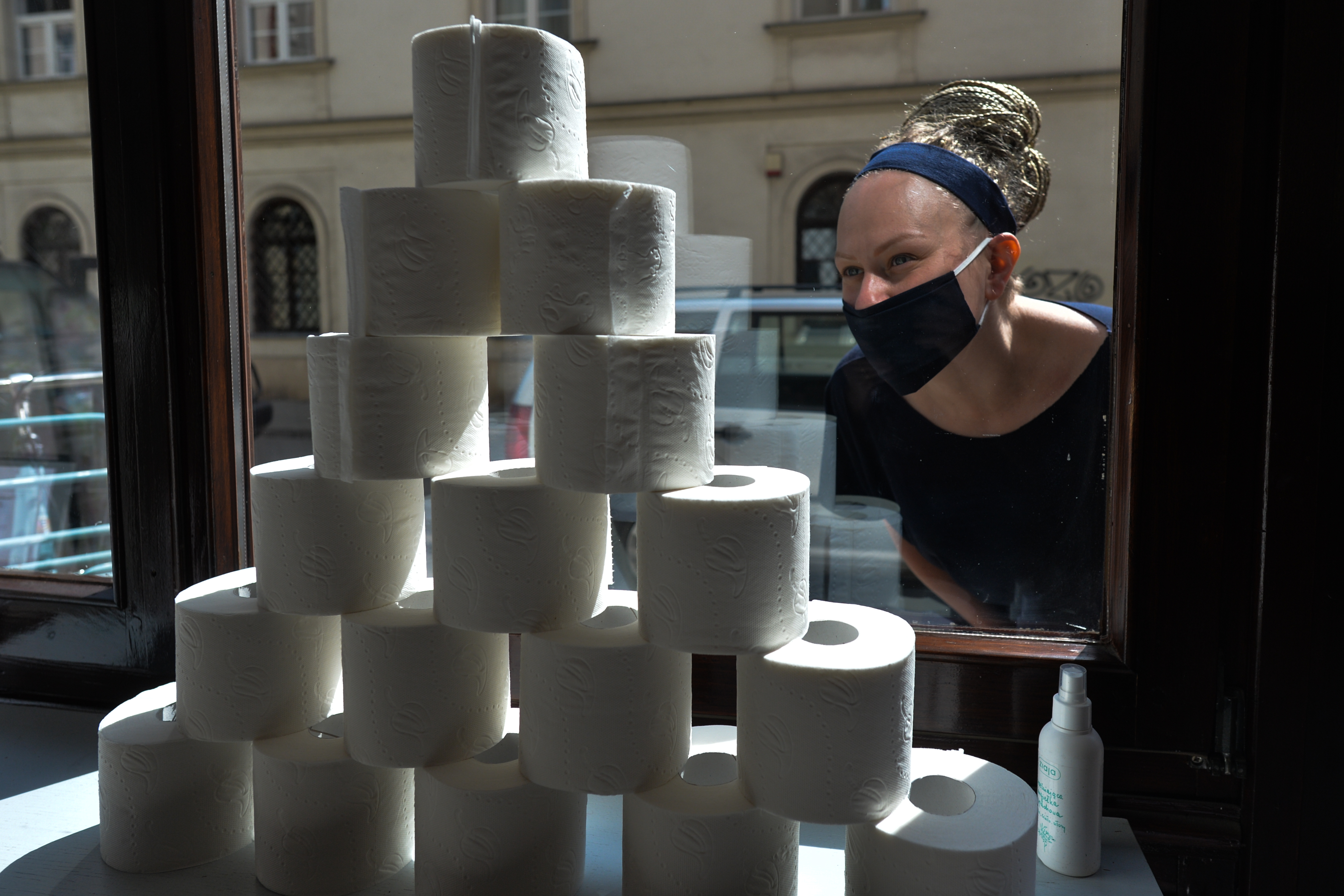 A shopper in Krakow, Poland gazes longingly at a pyramid of toilet paper on Friday, April 24, 2020. Toilet paper shortages have exposed weaknesses in the global supply chain - and made the tissue so precious it's practically currency.
