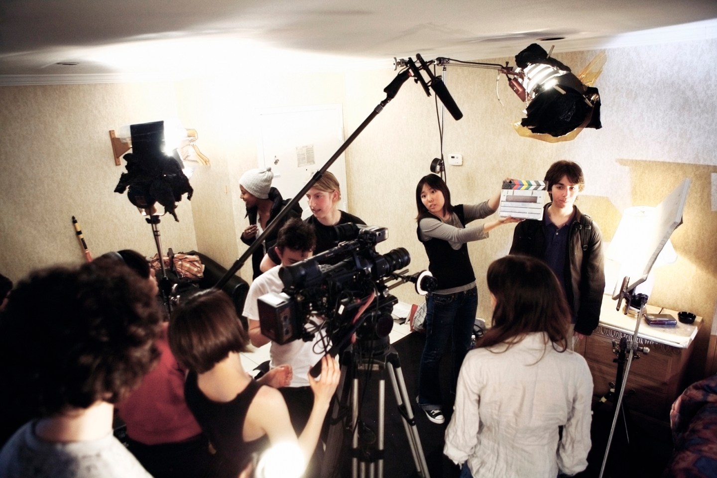 Film crew filming on location in a small room.