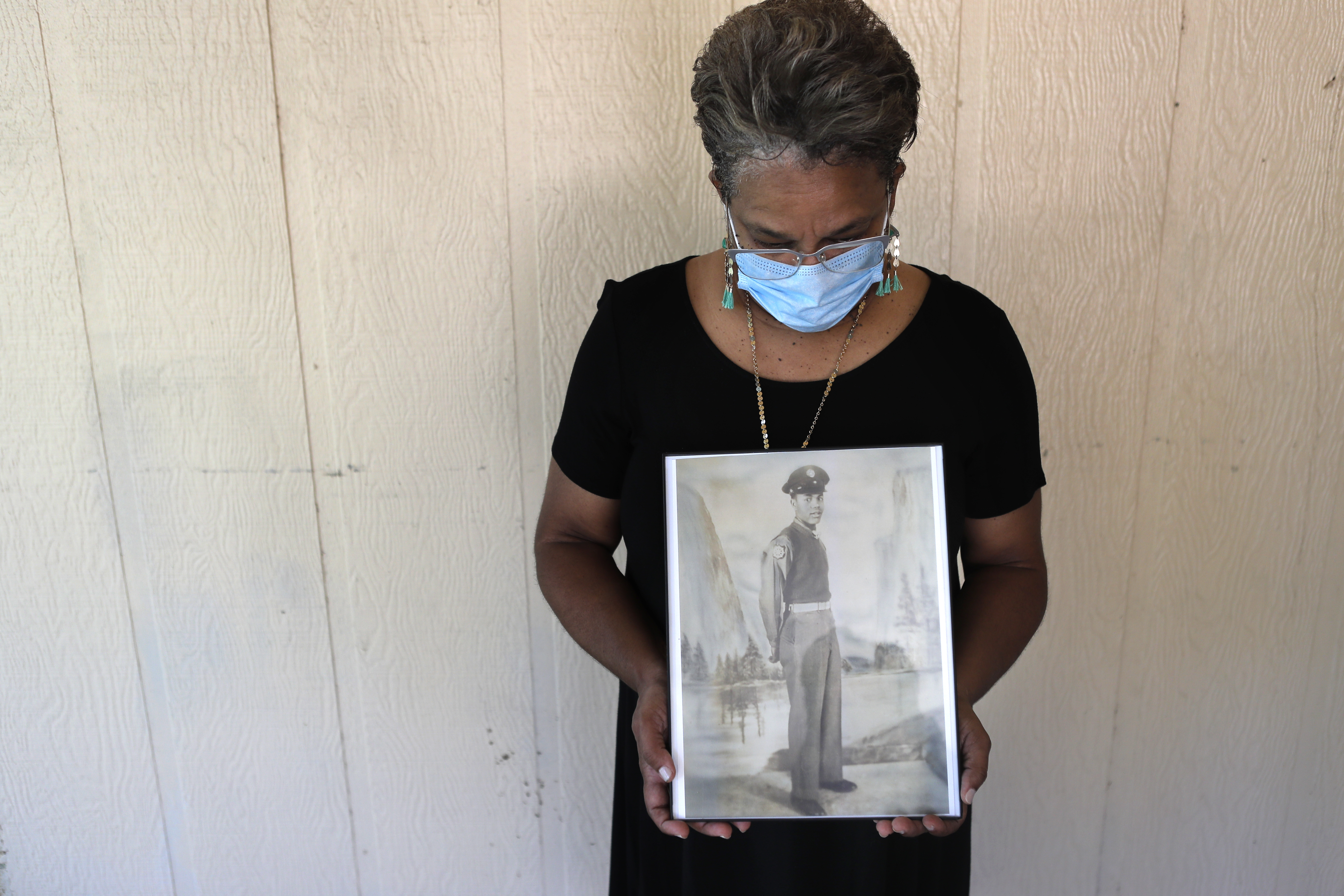 In this May 18, 2020 photo, Belvin Jefferson White poses with a portrait of her father Saymon Jefferson at Saymon's home in Baton Rouge, La. Belvin recently lost both her father and her uncle, Willie Lee Jefferson, to COVID-19. African Americans are disproportionately likely to say a family member or close friend has died of COVID-19 or respiratory illness since March, according to a series of surveys conducted since April that lays bare how black Americans have borne the brunt of the pandemic.  Gerald Herbert—AP Photo
