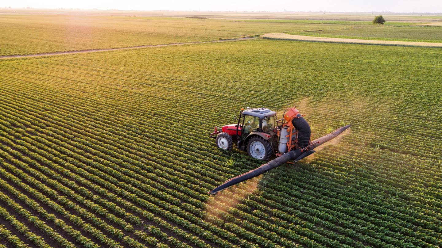 tractor sprays soybeans