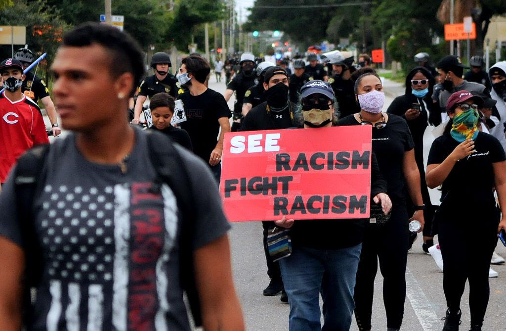 A protester holds a placard while marching to Orlando City
