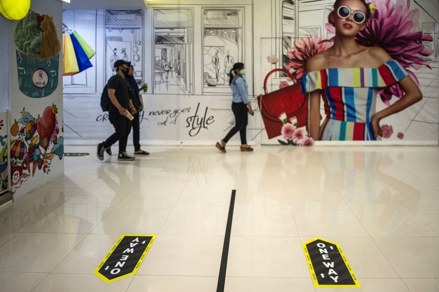 Indonesians walk around a shopping mall that applies social and physical distancing with a plastic divider and lane direction amid concern to the COVID-19 coronavirus pandemic in Surabaya on June 10, 2020.