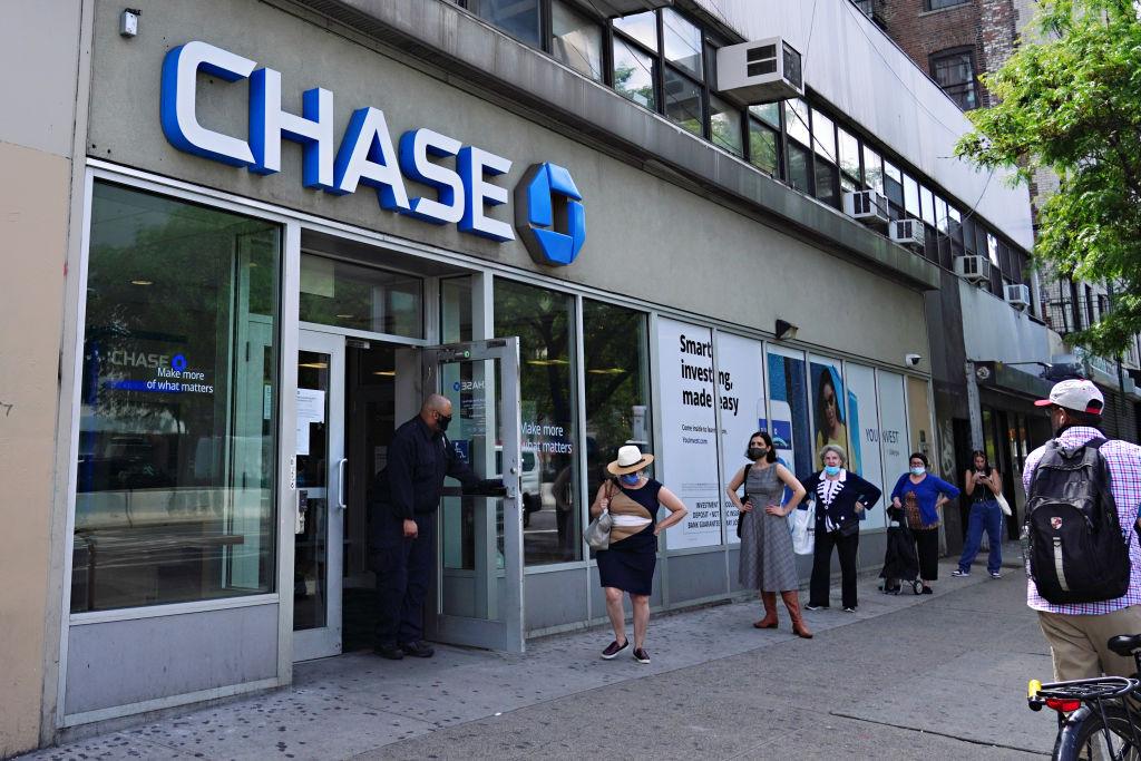 People wait in line to use a Chase bank ATM