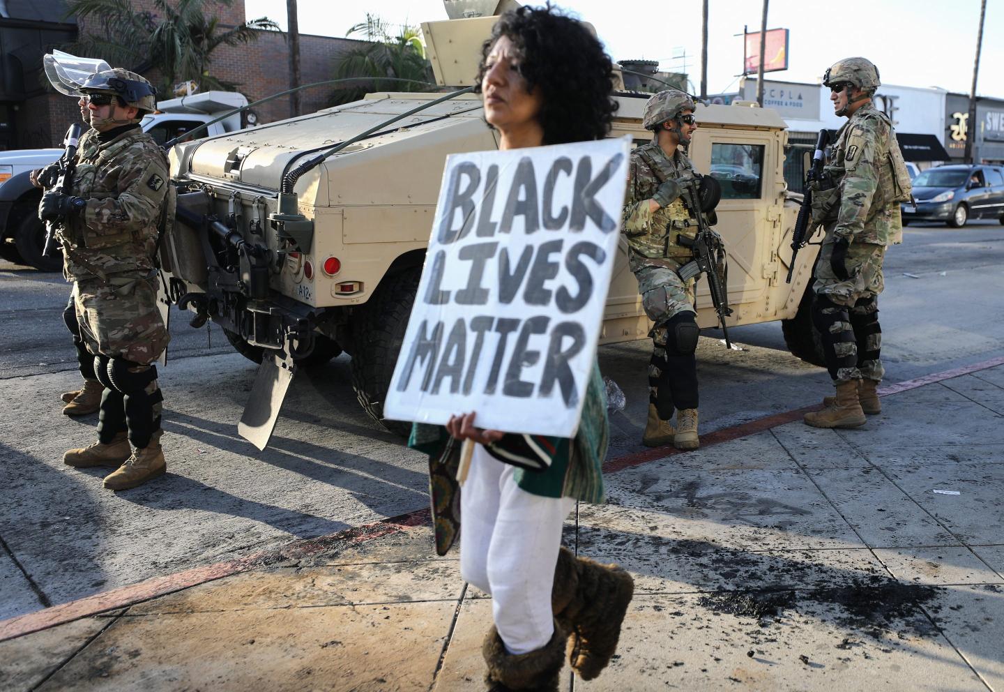 woman carries black lives matter sign