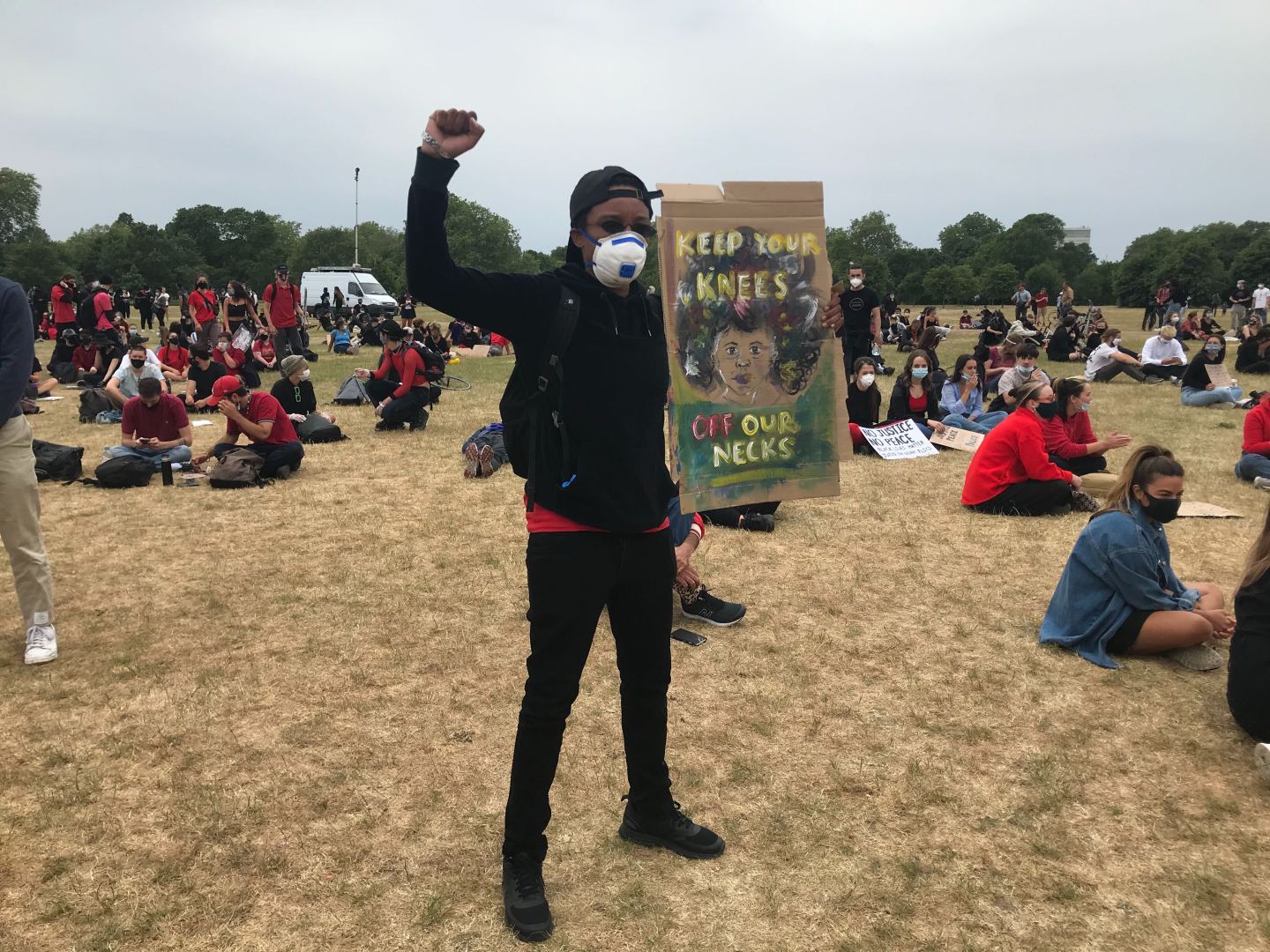 Protestor holds a sign reading "keep your knees off of our necks" at Hyde Park protest for George Floyd murder