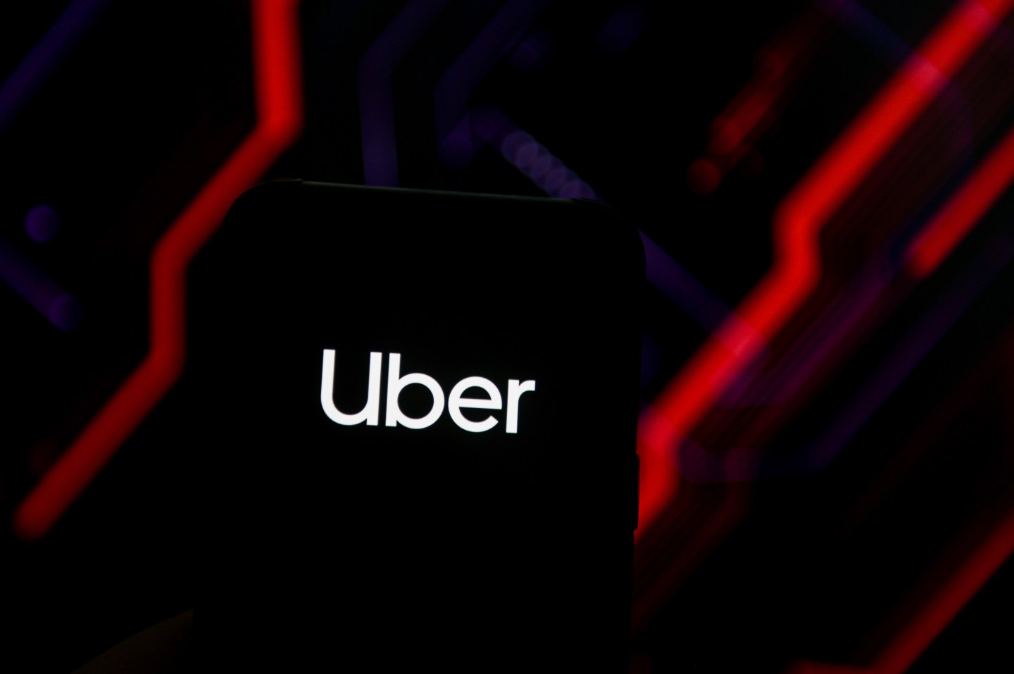 In this photo illustration an Uber logo is seen displayed on a smartphone.