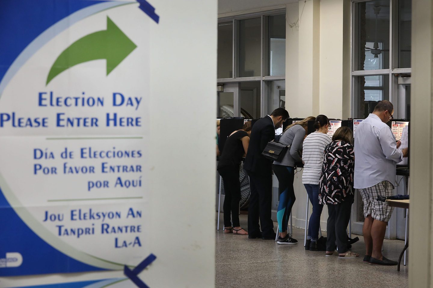 Voters fill out their ballots as they cast their vote at a polling station setup in Legion Park for the mid-term election on November 6, 2018 in Miami, Florida.
