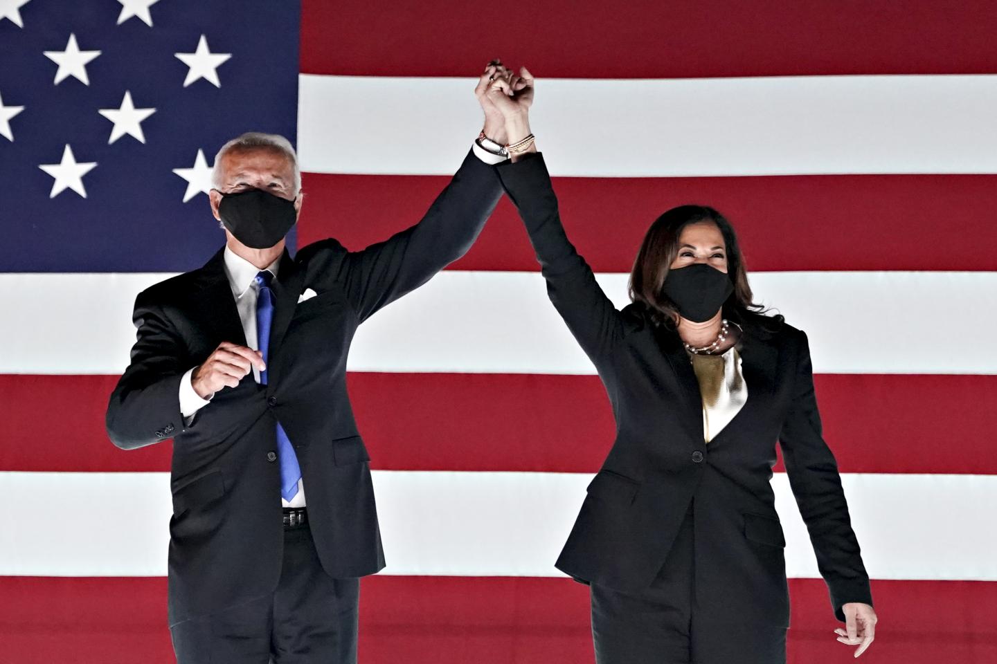 Former Vice President Joe Biden, Democratic presidential nominee, left, and Senator Kamala Harris, Democratic vice presidential nominee, wear protective masks while holding hands outside the Chase Center during the Democratic National Convention in Wilmington, Delaware, U.S., on Thursday, Aug. 20, 2020.