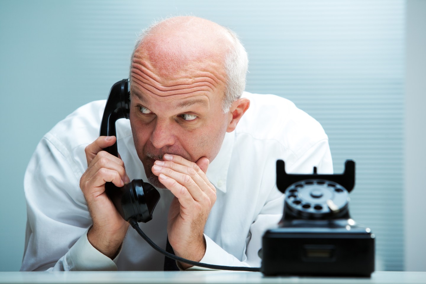 Photo of an executive whispering into a telephone