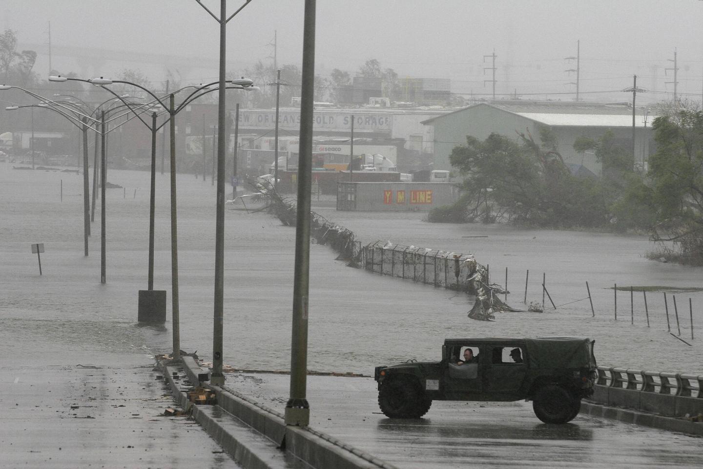 A military vehicle surveys the situation on Sept. 23, 2005 as water floods back into streets of the Ninth Ward after surge waters from Hurricane Rita topped over a patched section of the levee along the Industrial Canal, which had given way during Hurricane Katrina in New Orleans.