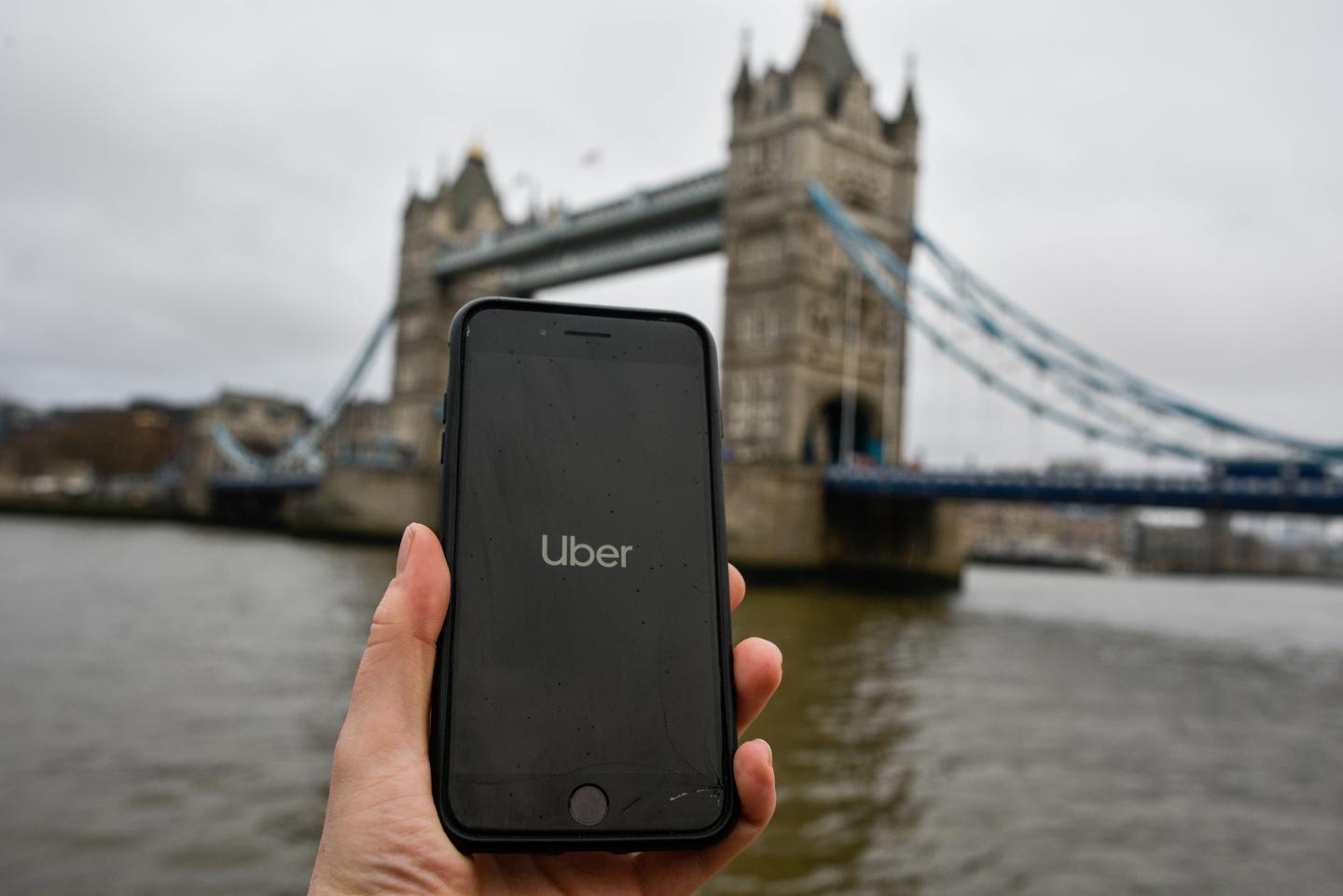 In this photo illustration the Uber logo is displayed on a phone in front of Tower Bridge on November 25, 2019 in London, England.