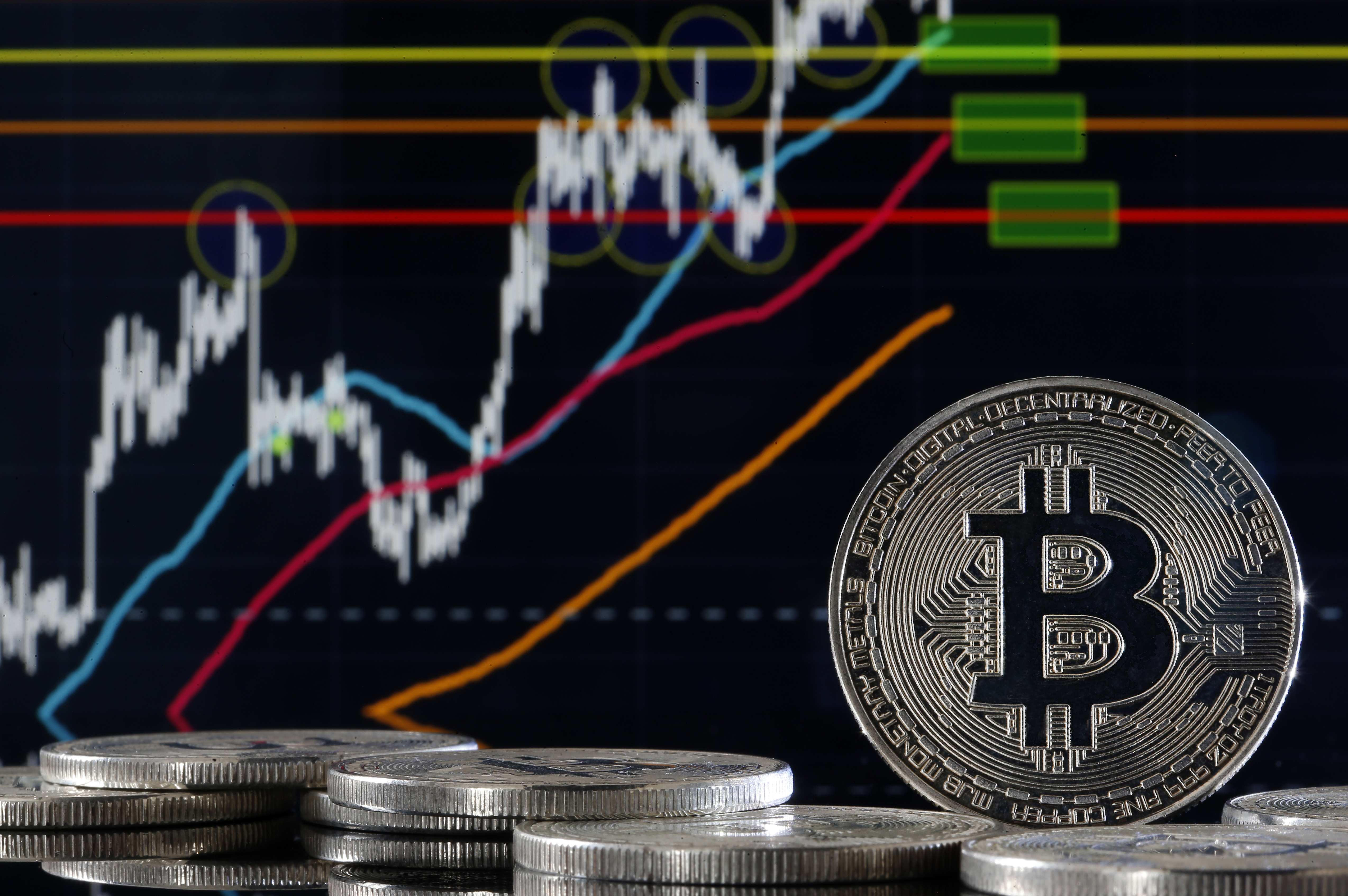 PARIS, FRANCE - FEBRUARY 12: In this photo illustration, a visual representation of the digital Cryptocurrency, Bitcoin is displayed in front of the Bitcoin course's graph on February 12, 2020 in Paris, France. The price of Bitcoin is rising and has once again passed above the very symbolic bar of 10,000 US dollars. (Photo by Chesnot/Getty Images)