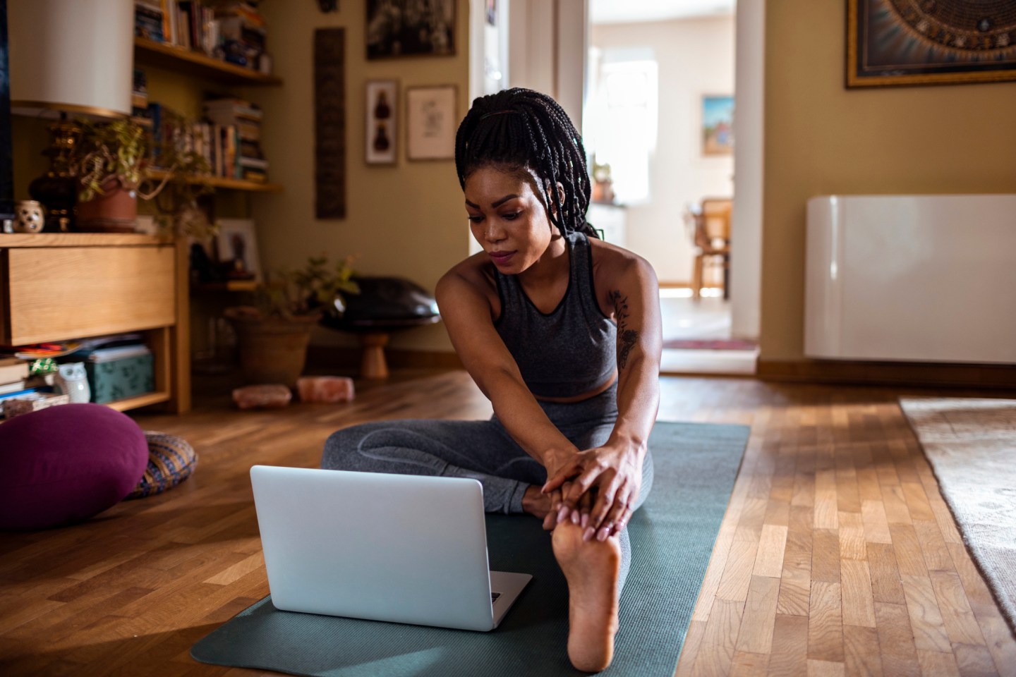 Close up of a young woman learning yoga online from her laptop