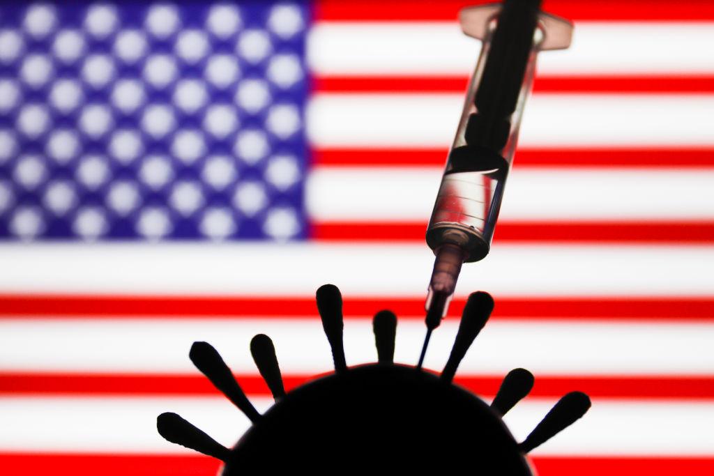 Image of a syringe injecting a coronavirus in front of an American flag.