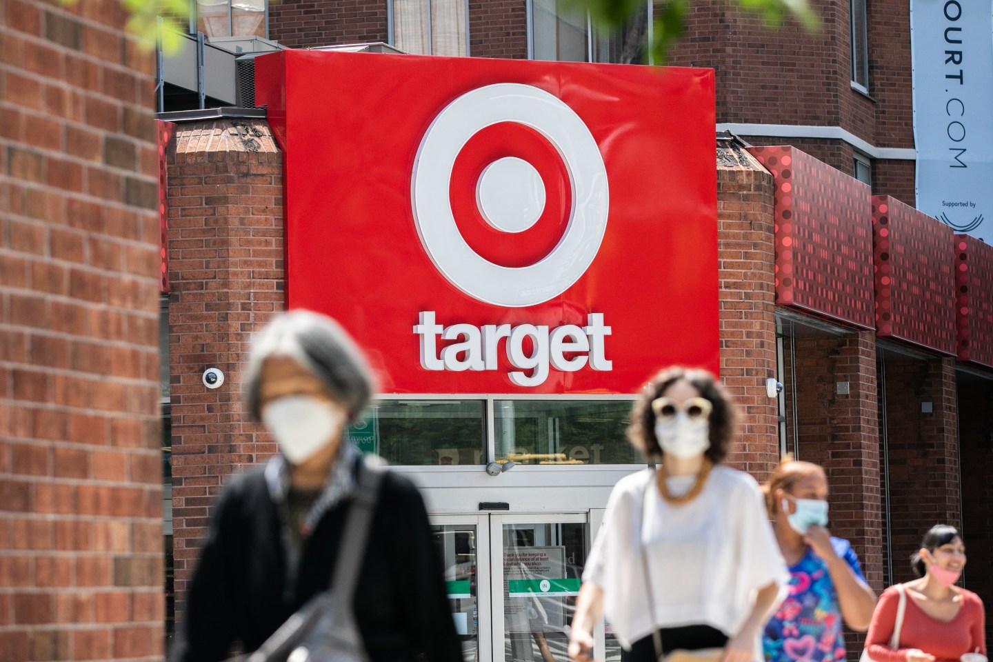 Pedestrians wearing protective masks walk past a Target Corp. store in New York, U.S., on Monday, Aug. 17, 2020.