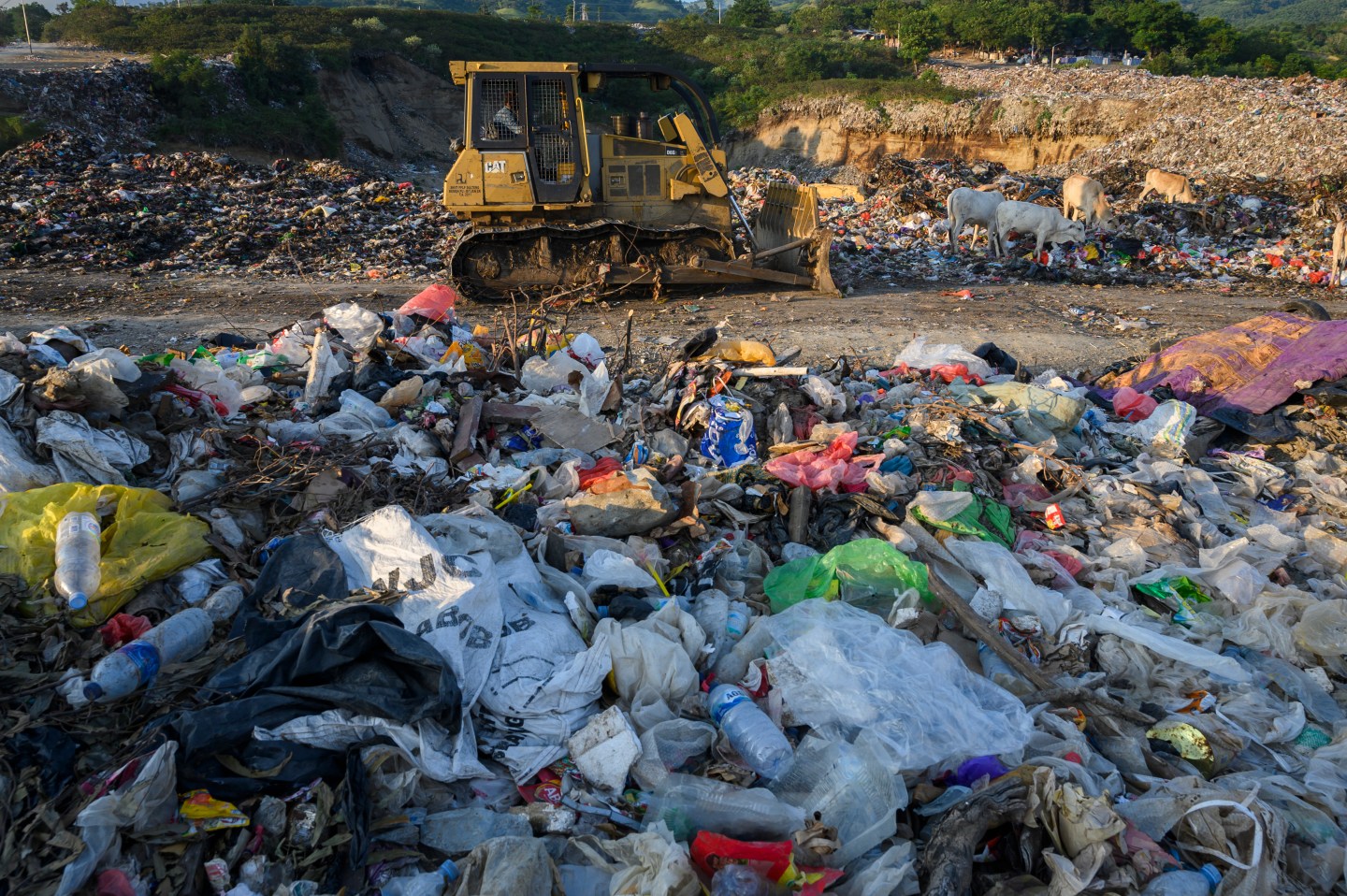 Heavy equipment operators displace rubbish piles at the Kawatuna Landfill, Palu, Central Sulawesi Province, Indonesia on August 24, 2020.