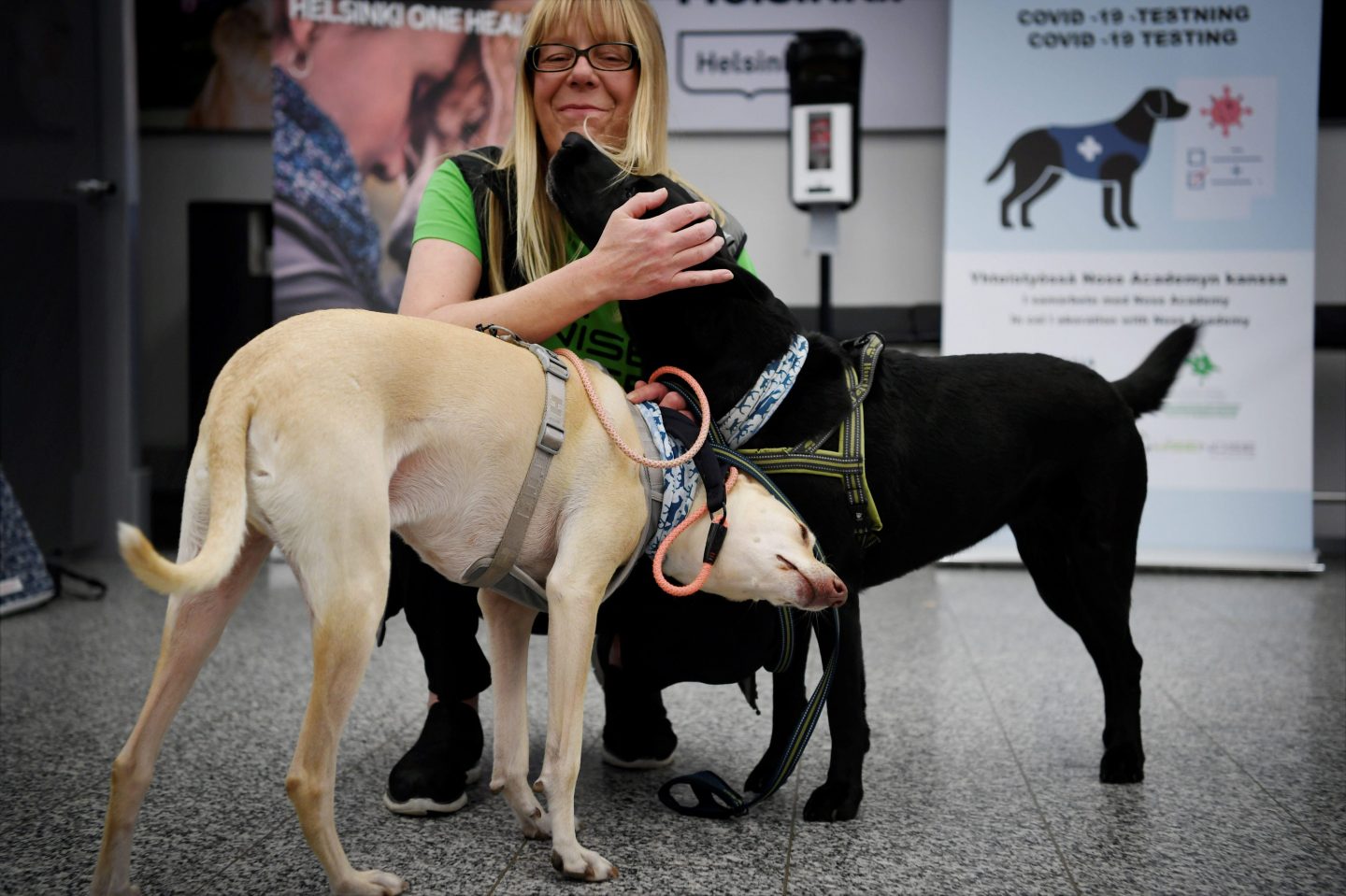 The coronavirus sniffer dogs named Kössi (L) and Miina cuddle with trainer Susanna Paavilainen at the Helsinki airport in Vantaa, Finland where they are trained to detect COVID-19 from the arriving passengers.