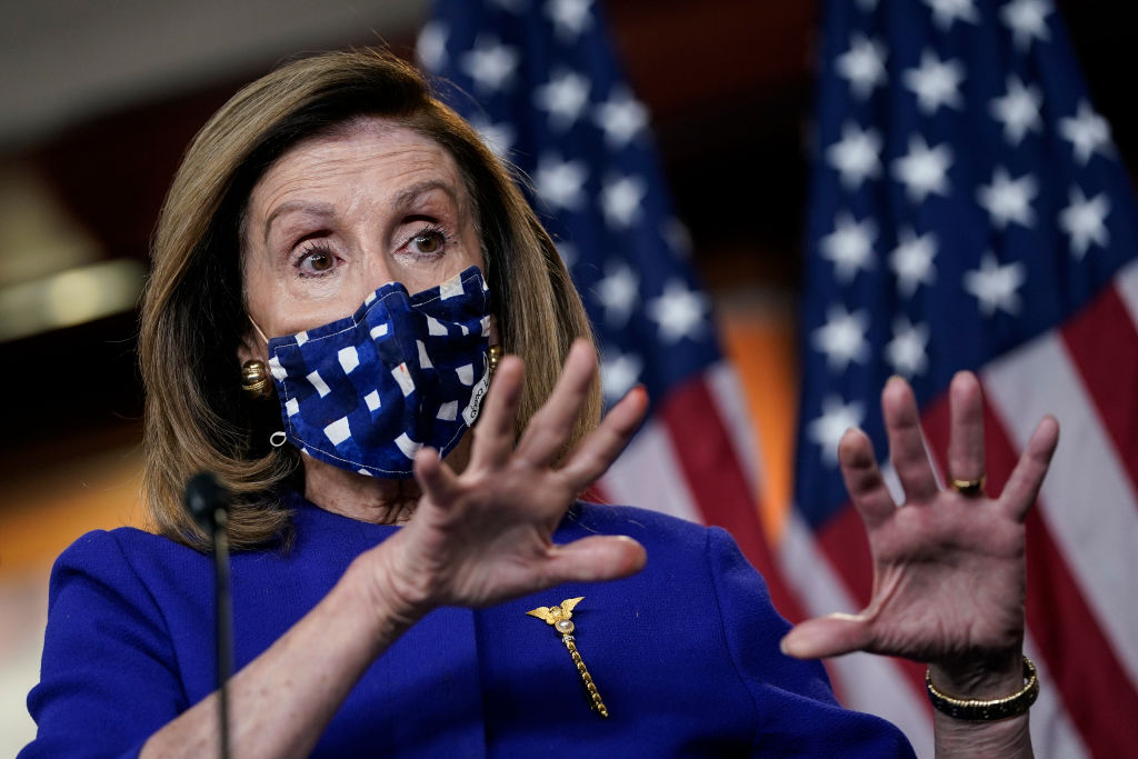 Photo of U.S. Speaker of the House Nancy Pelosi wearing a mask and gesturing with her hands.