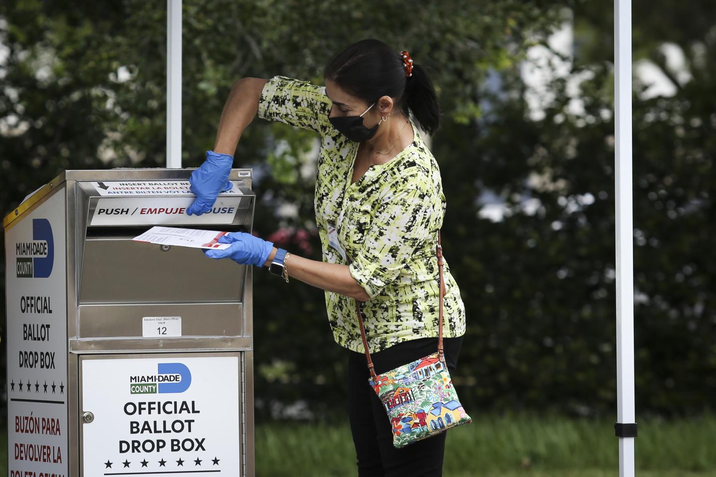 An election official places a mail-in ballot in a drop box in Miami. The CEOs of America’s biggest companies must speak out against threats to election integrity and the peaceful transfer of power, writes Bennett Freeman.