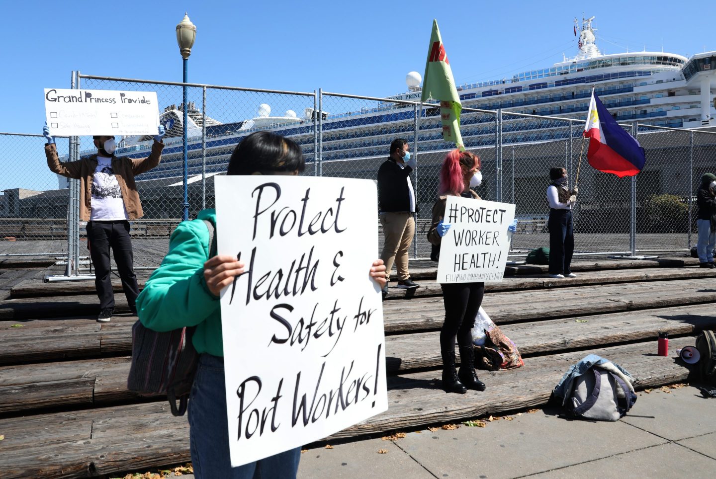 The Grand Princess cruise ship docks at Pier 35 for resupply as members of the Filipino Community Center protest perceived lack of health protections for Filipino Grand Princess workers not able to dock in the Philippines on Tuesday, April 7, 2020, in San Francisco, Calif.