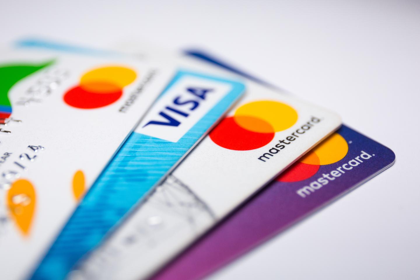 Four credit cards lay fanned out on a white surface