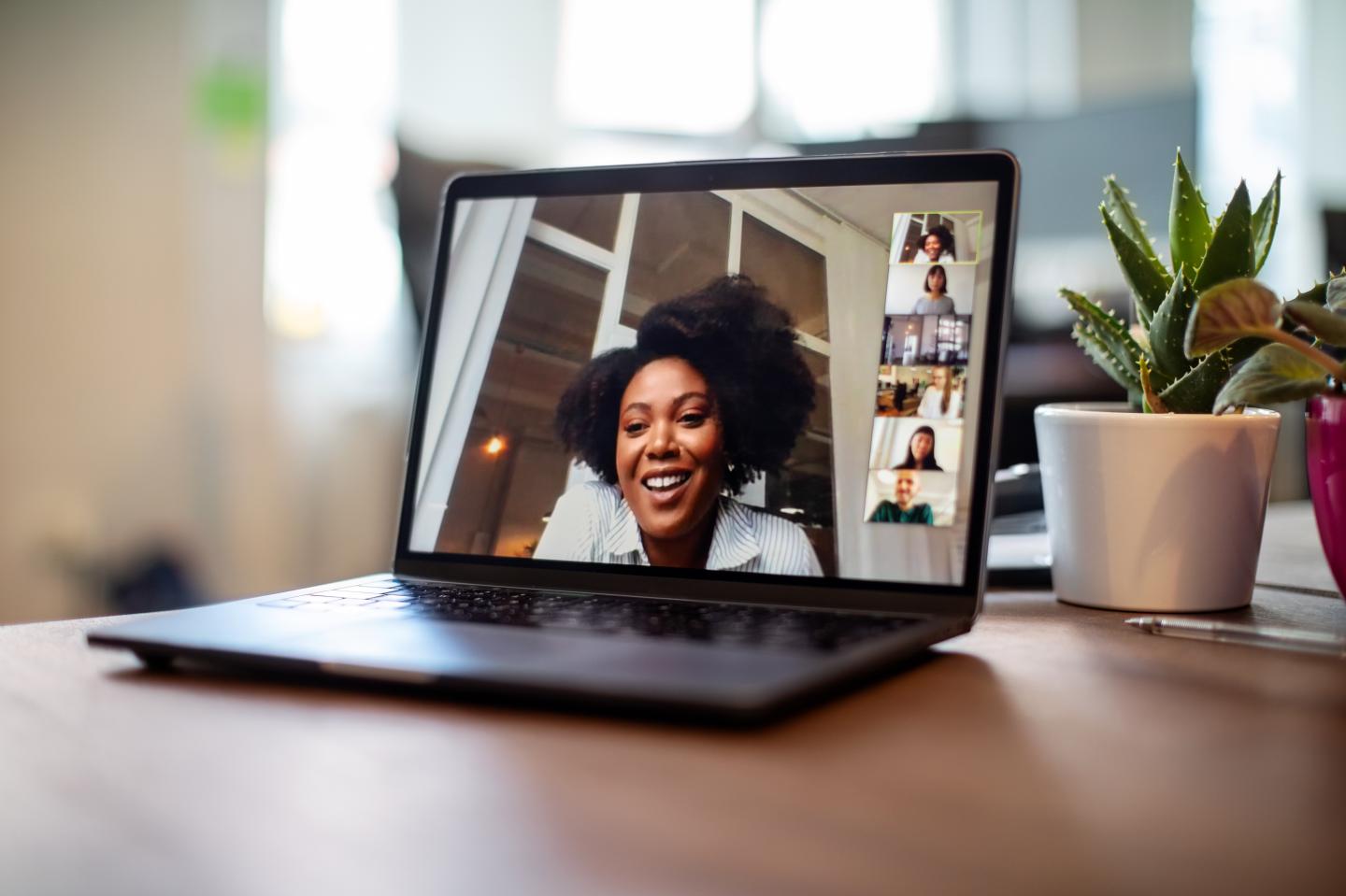 Shot of businesswoman having a video call on a laptop with her team. Woman having meeting on video call on laptop with colleagues