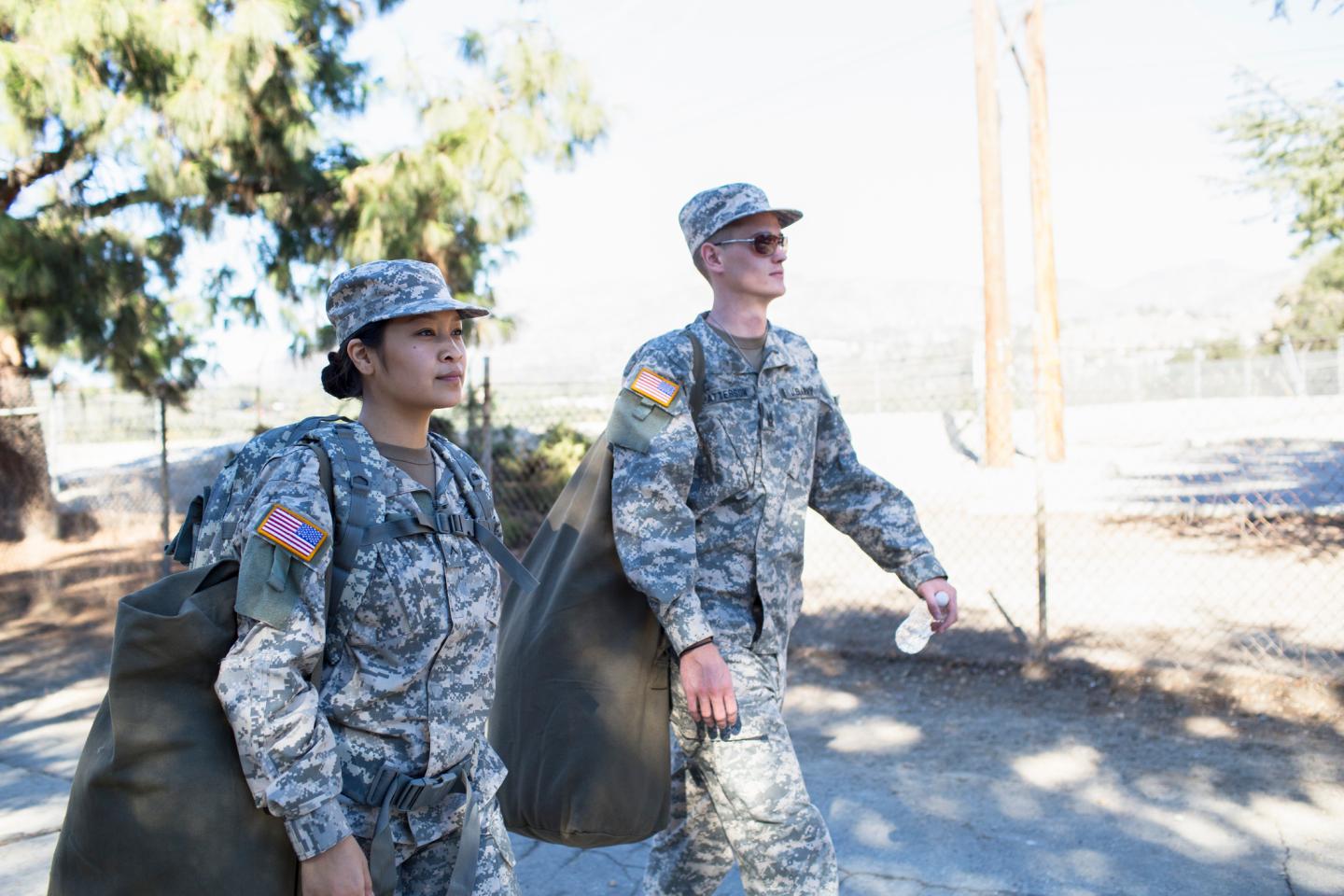Two U.S. Army soldiers - a man and a woman walking side by side.