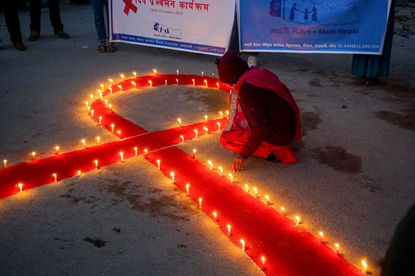 A woman in Kathmandu, Nepal, lights candles surrounding a red-ribbon AIDS awareness symbol on Nov. 30, the eve of World AIDS Day.