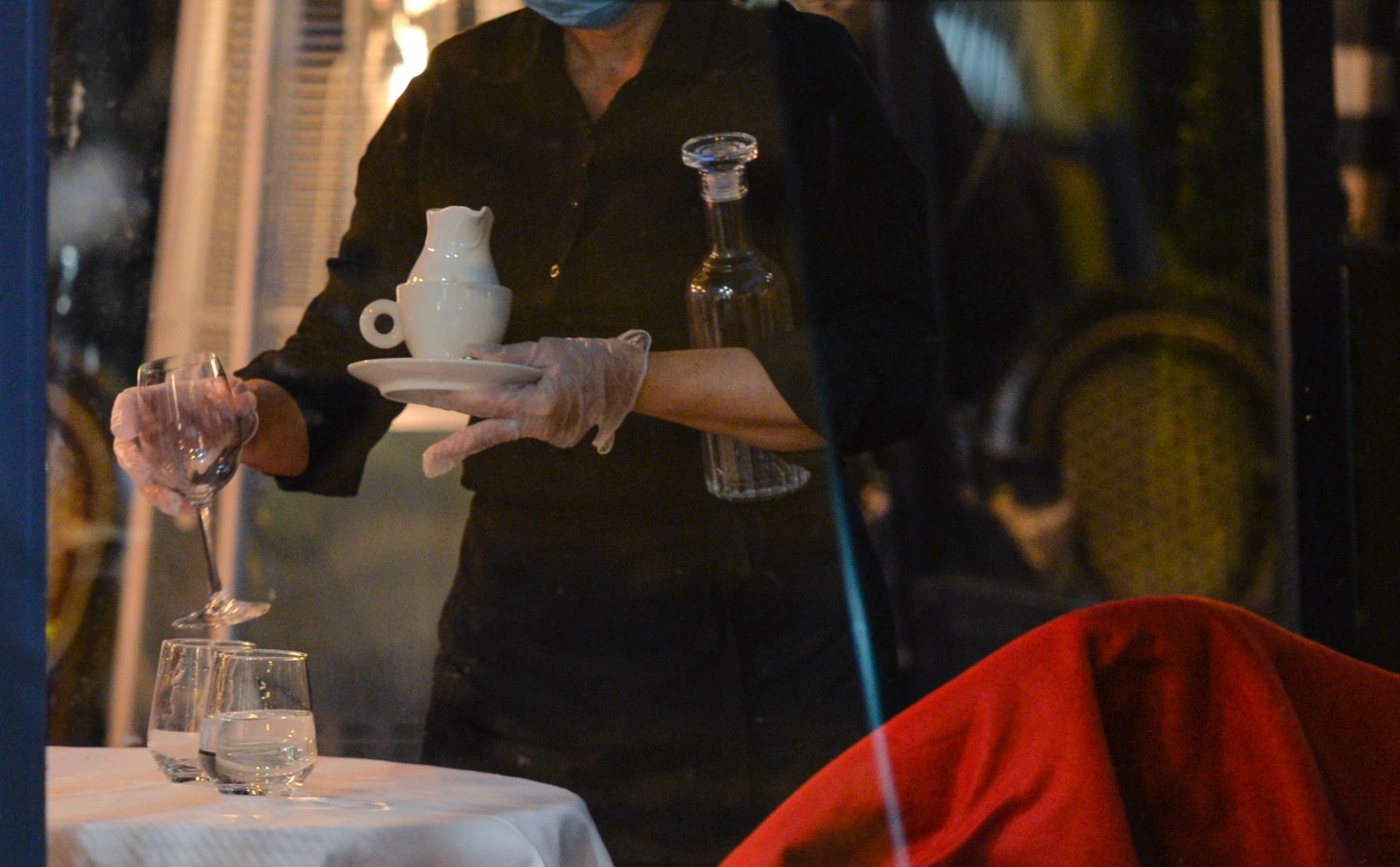 A waitress clears a table.