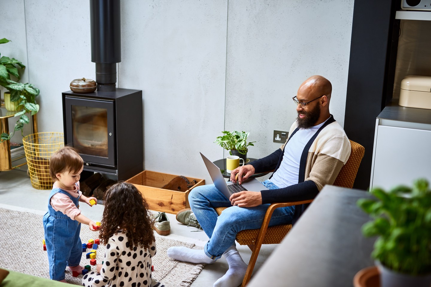 man works at home with two kids