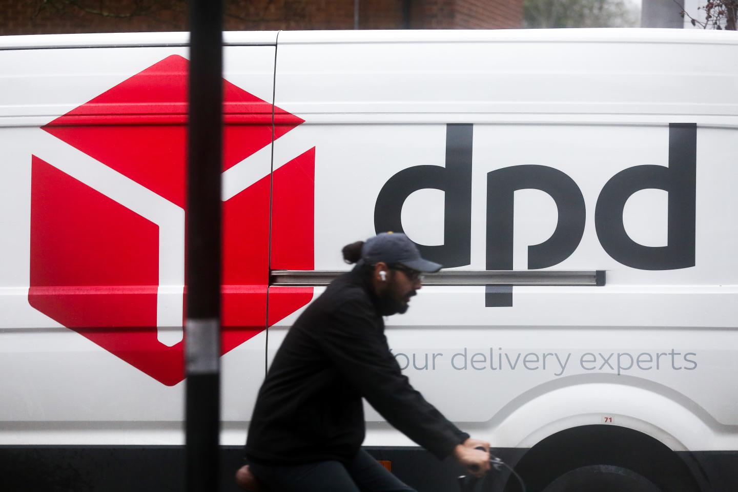 2020/12/16: A cyclist rides past a DPD delivery van in London.