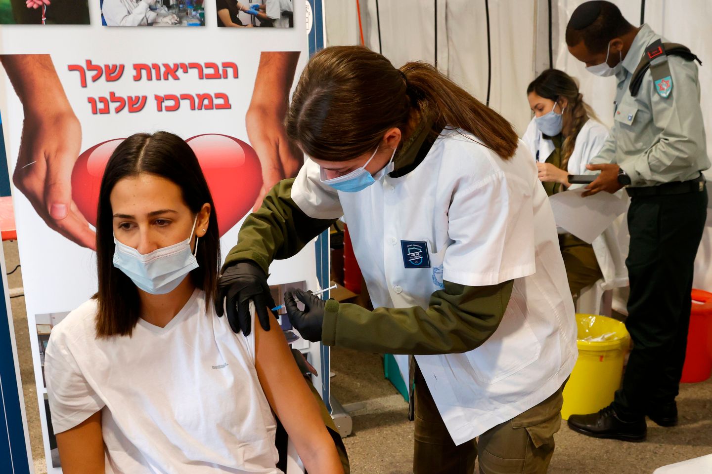 An Israeli military medic gets vaccinated against the COVID-19 coronavirus at the medical centre of Tzrifin military base in the Israeli town of Rishon Lezion on December 28, 2020.