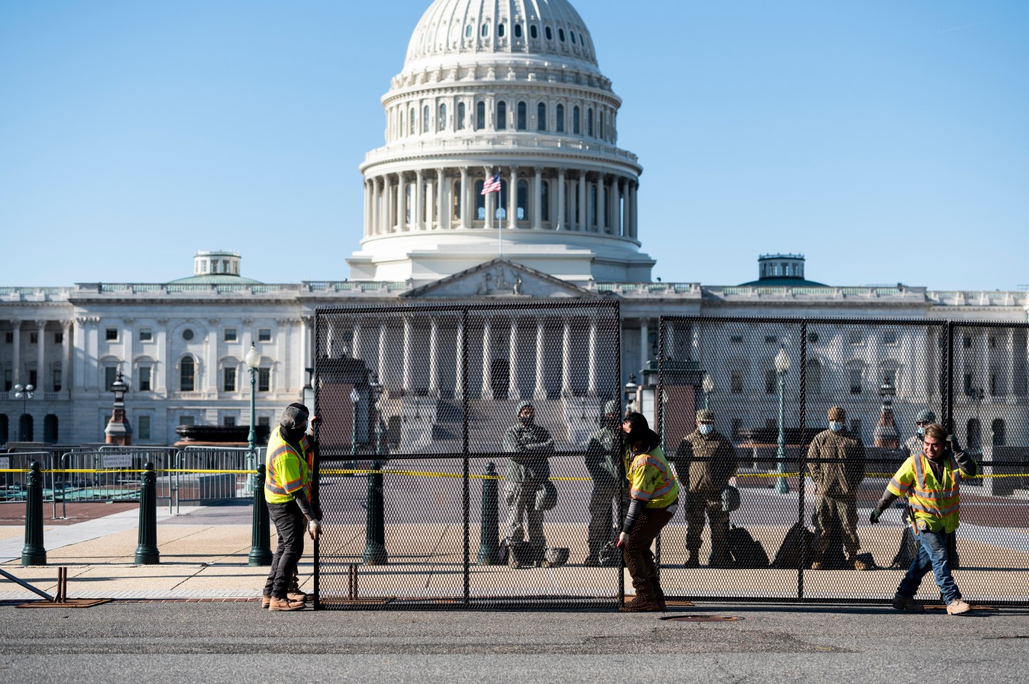 Workers install more robust fencing along the east side of the U.S. Capitol on Thursday morning.
