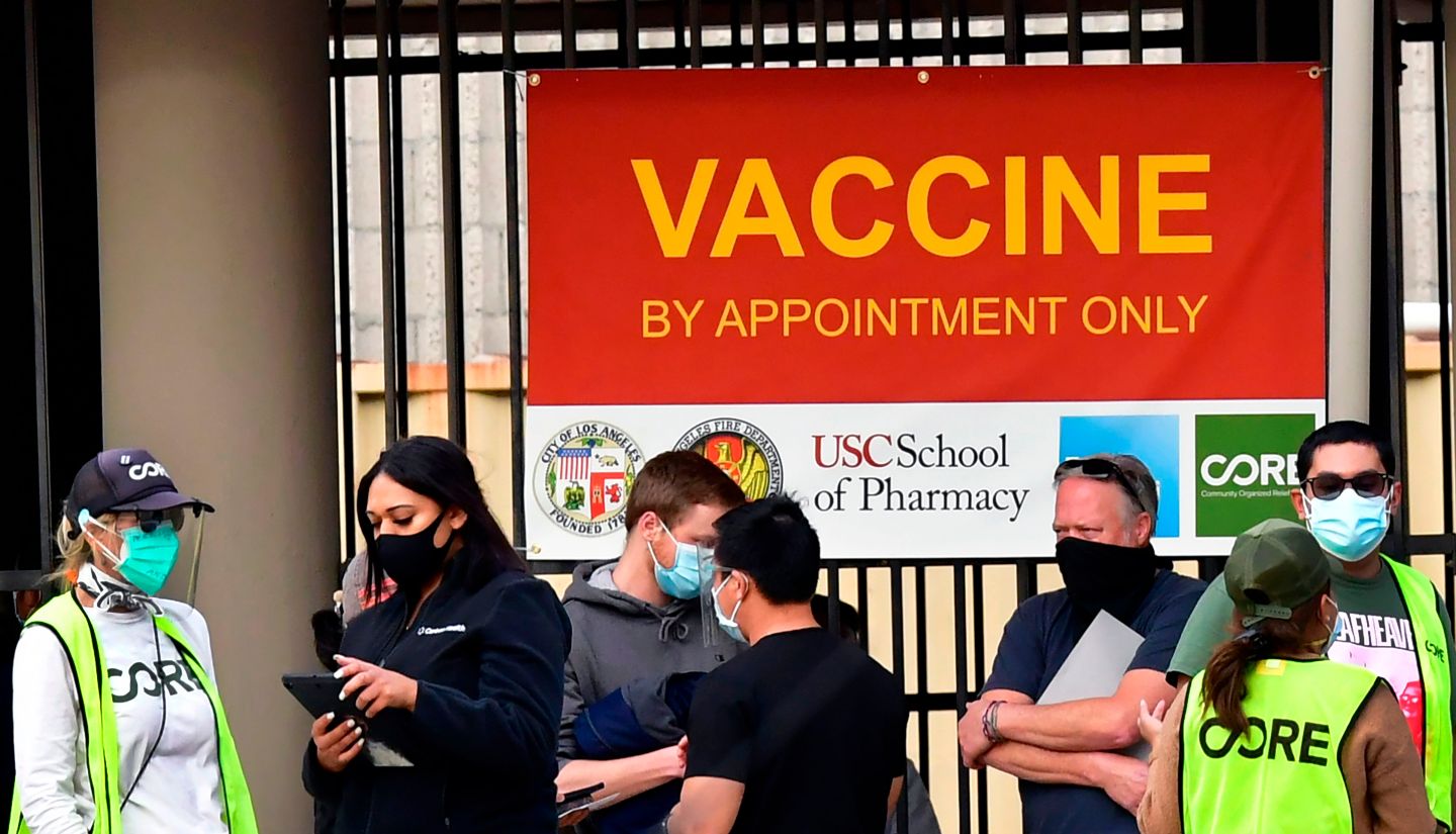 People wait for injections at a vaccination facility in Los Angeles on Jan. 12. In the COVID vaccine rollout, write the authors, “the vacuum of guidance from the top means we all suffer—and some of us die.”