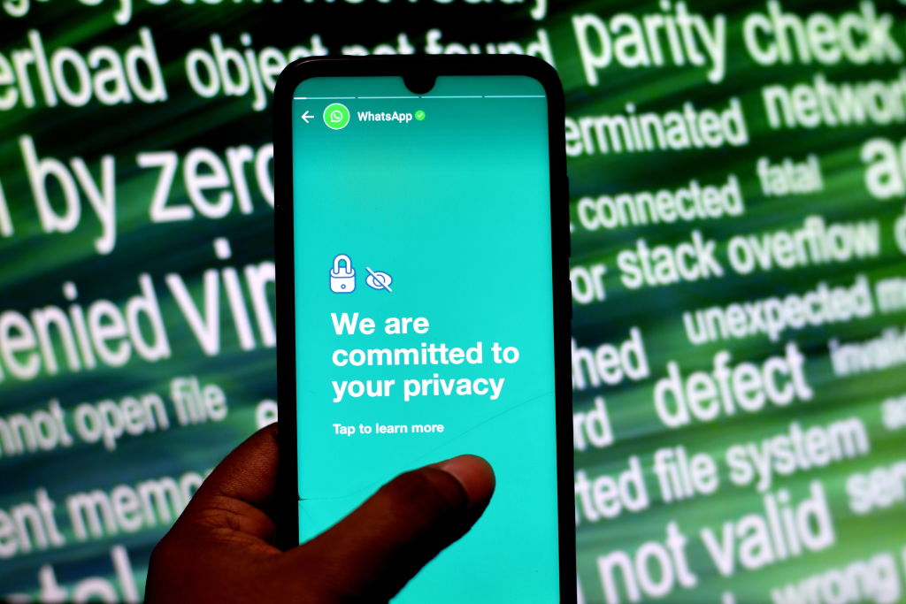 A photo of a person holding a mobile phone with a message from WhatsApp saying the company takes user privacy seriously displayed.