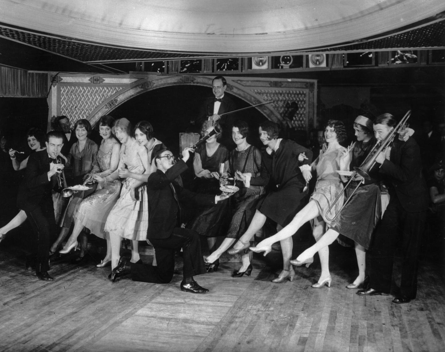 22nd January 1926: Female flappers kicking, dancing, and having fun while musicians perform during a Charleston dance contest at the Parody Club.