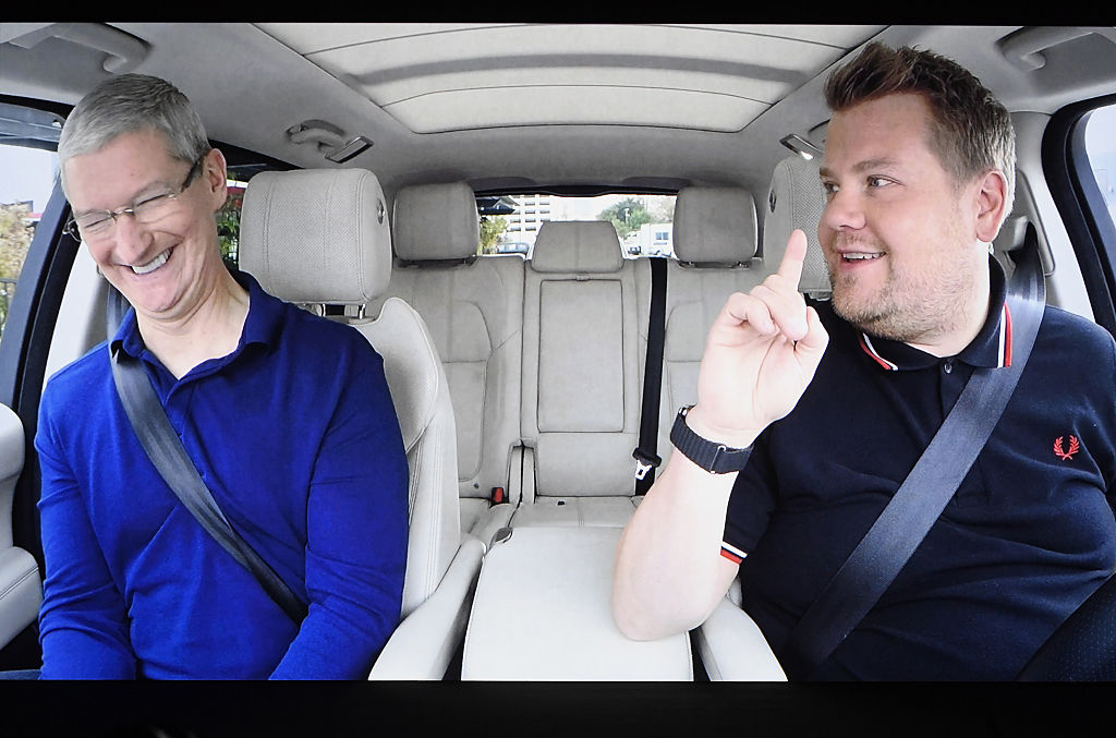 Tim Cook sitting in a car next to comedian James Corden.