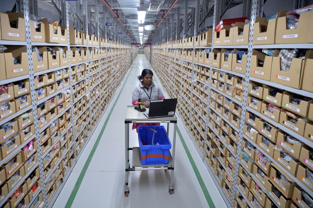 An employee of Amazon India retrieves products from an assorted storage area to fill orders placed by customers prior to packaging at Amazon’s newly launched fulfillment center on the outskirts of Bangalore on Sept. 18, 2018.