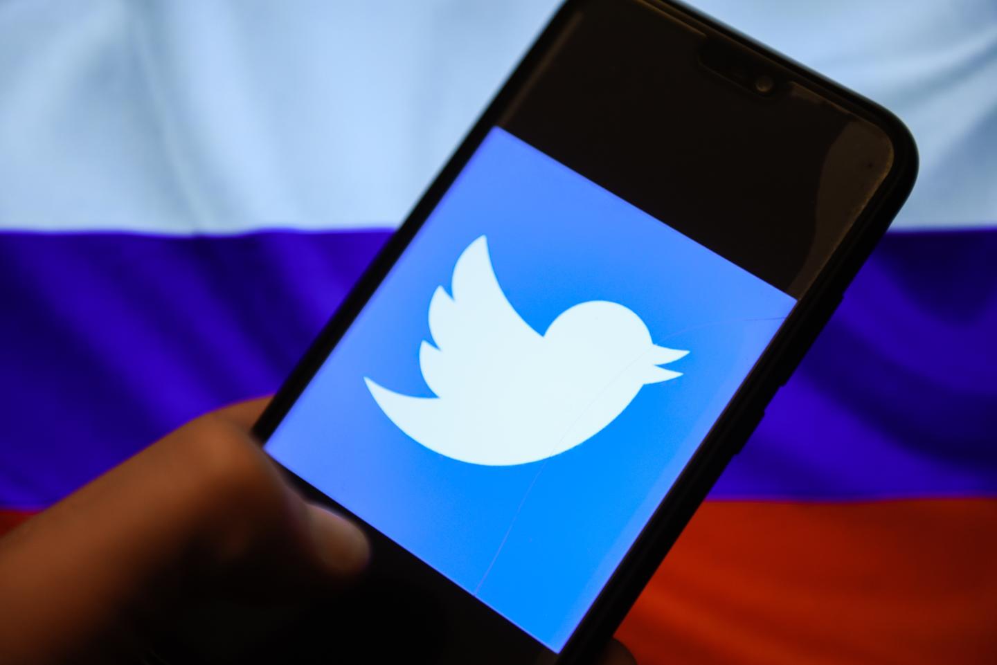 In this photo illustration, the Twitter logo and Russian flag are seen displayed on an Android mobile phone.
