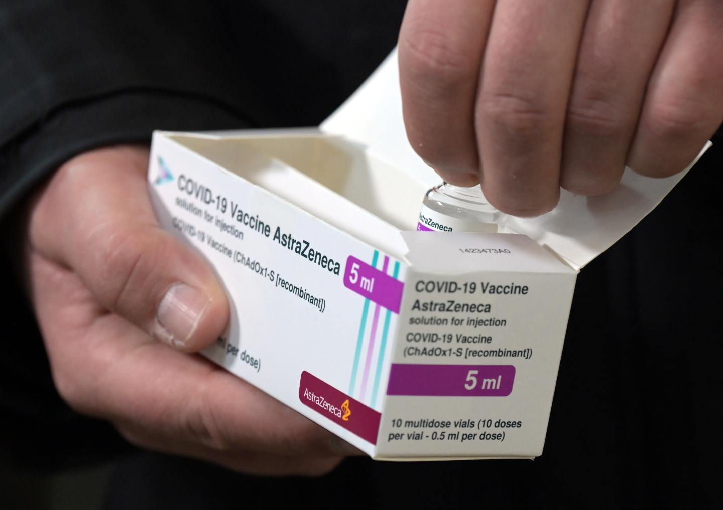 Silvio König, head of the vaccination center, takes a vial containing five milliliters of Astrazeneca's Corona vaccine out of its packaging in the entrance area of Terminal C of the former Tegel Airport at the Corona Vaccination Center in Berlin.