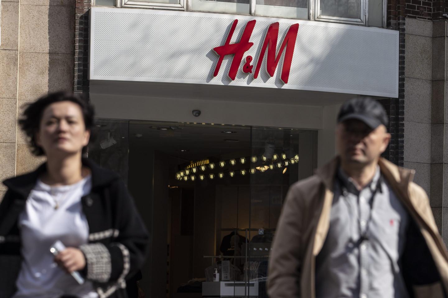 Pedestrians walk past a Hennes & Mauritz AB (H&M) store in Shanghai, China, on Friday, March 26, 2021. China this week has pushed a campaign to boycott Western retailers after the U.S., U.K., Canada and the European Union imposed sanctions over human-rights abuses against ethnic minority Uyghurs in Xinjiang.