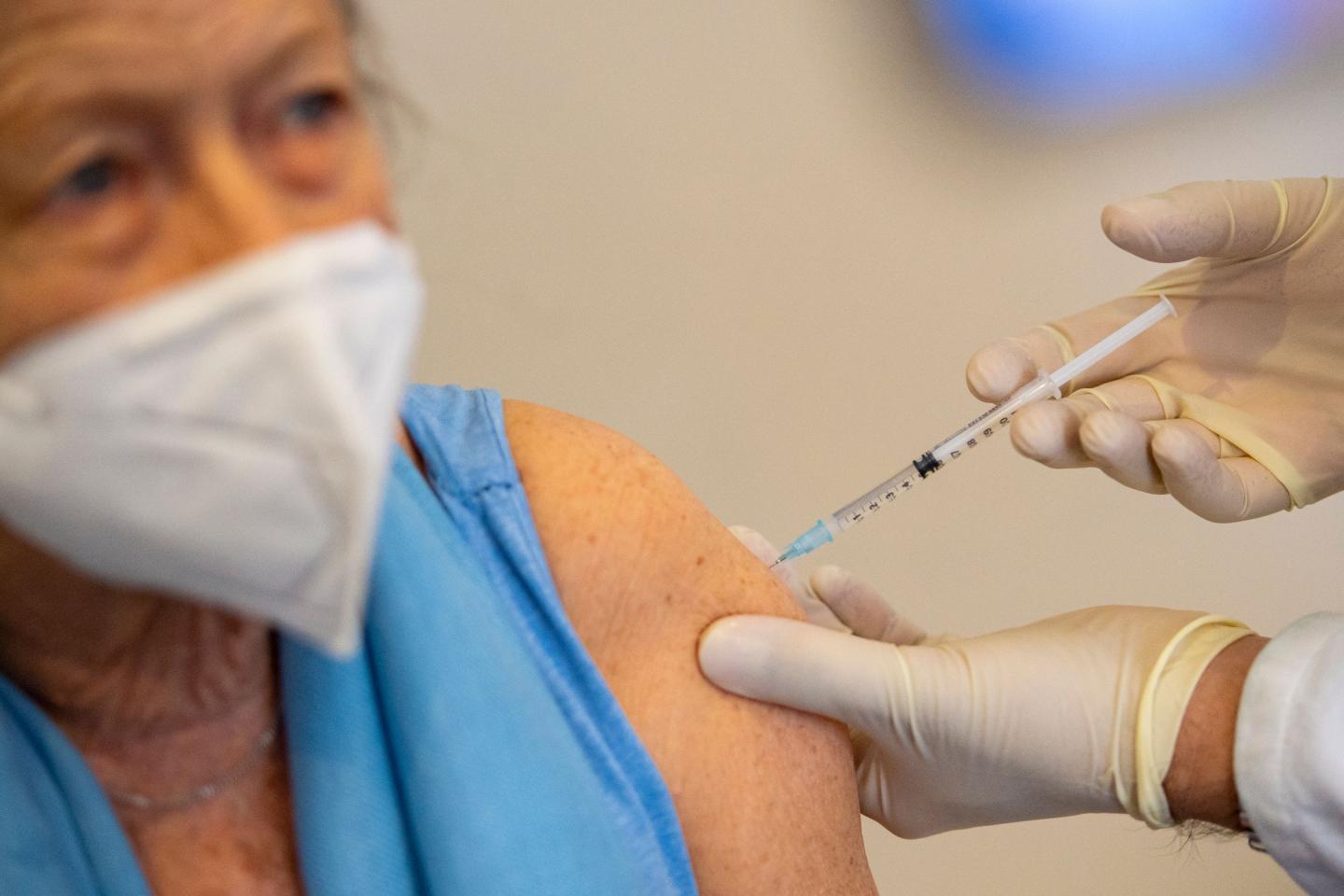 General practician Oliver Abbushi vaccinates patient Dorothea Robert with AstraZeneca's vaccine against the coronavirus (Covid-19) at his doctor's office in Deisenhofen, southern Germany, on March 31, 2021, amid the ongoing pandemic.