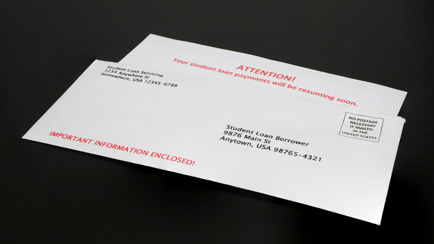 Student Loan Payment Resuming Notice in Envelope on Black Desk, right angled.
