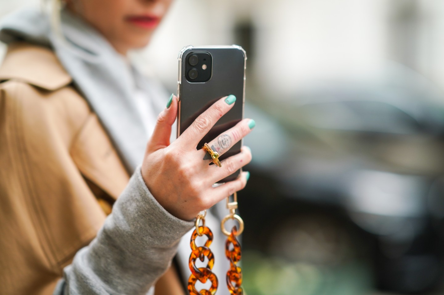 Emy Venturini wears a golden finger ring, holds an Apple Iphone mobile phone with a brown amber long chain, on February 22, 2021 in Paris, France.