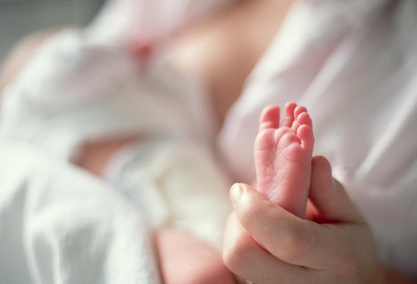 Mother Holding Newborn's Tiny Foot
