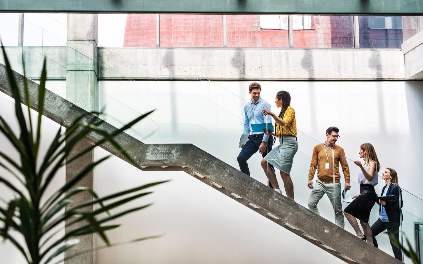 Business people walk up a set of stairs.