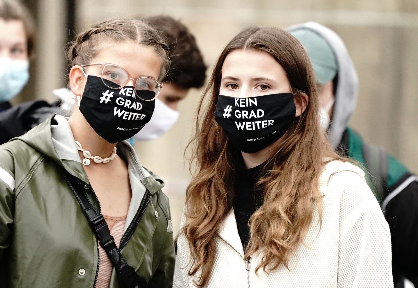 25 September 2020, Berlin: Climate activists Luisa Neubauer (r) and Leonie Bremer of Fridays for Future take part in the demonstration at an international climate protest day for more speed in the fight against the climate crisis. They wear a mouth-nose cover with the motto "#No degree further".