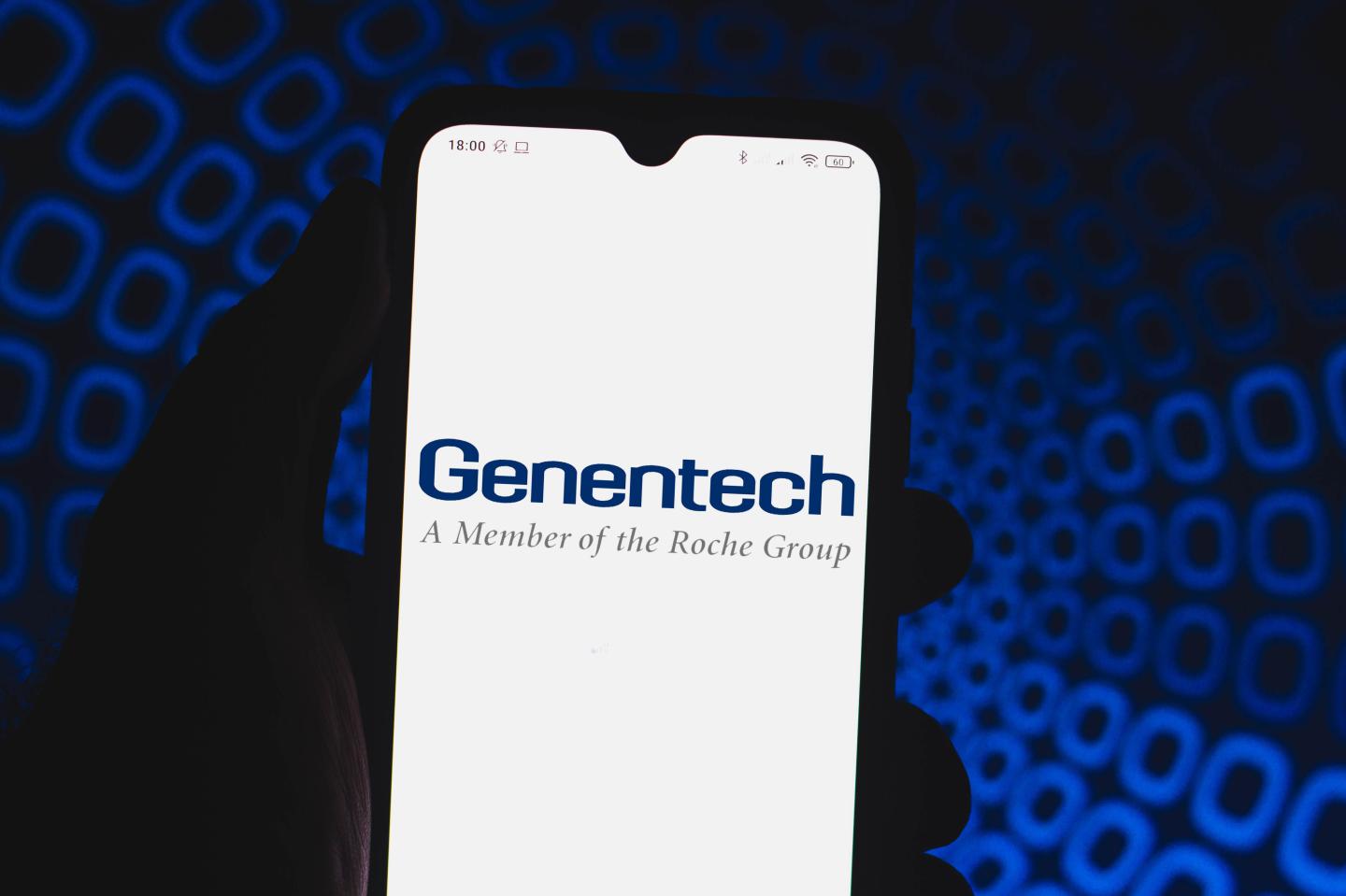In this photo illustration a Genentech logo seen displayed on a smartphone.