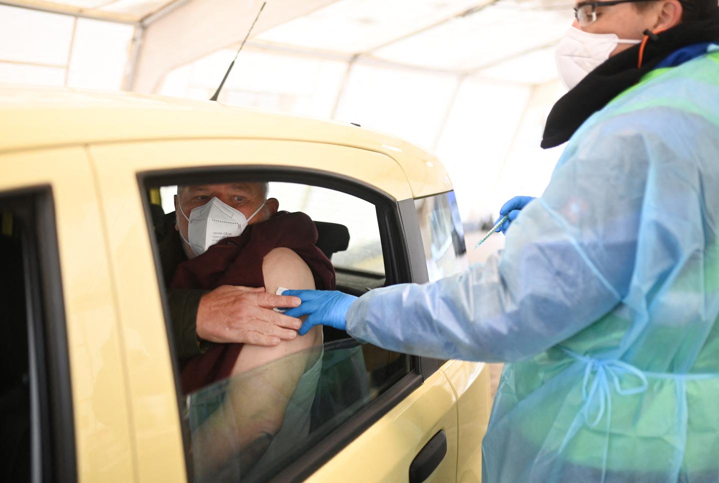 Medical personnel vaccinates a man with an injection of AstraZeneca vaccine against the coronavirus (Covid-19) at a drive-in vaccination centre in Schwelm, western Germany, on April 7, 2021, amid the ongoing pandemic.