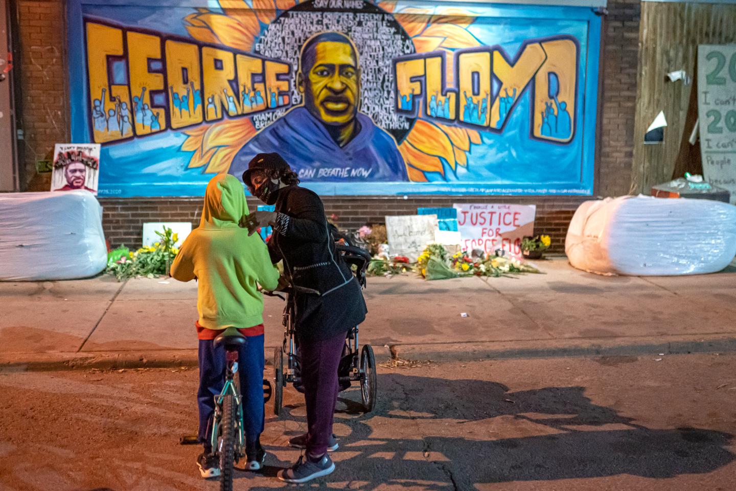 Shannon Haynes talks to her son Ronald Haynes, 9, about George Floyd in front of a memorial following the verdict in the Derek Chauvin trial on April 20, 2021 in Minneapolis, Minnesota.